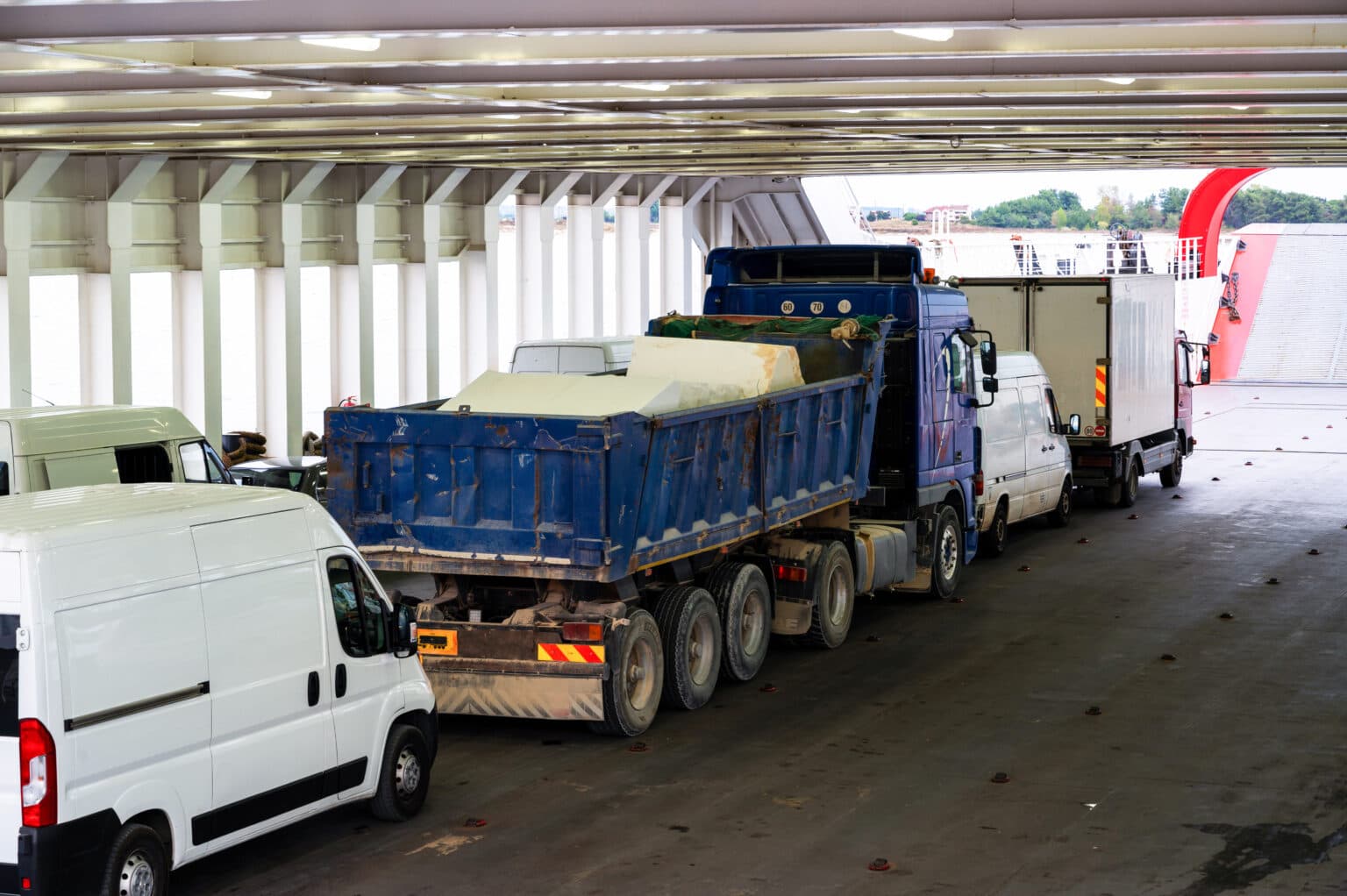 Transporter und LKW stehen in einer Halle hintereinander.